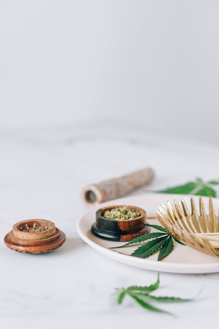 Cannabis leaves and grinder on a plate, perfect for herbal lifestyle themes.